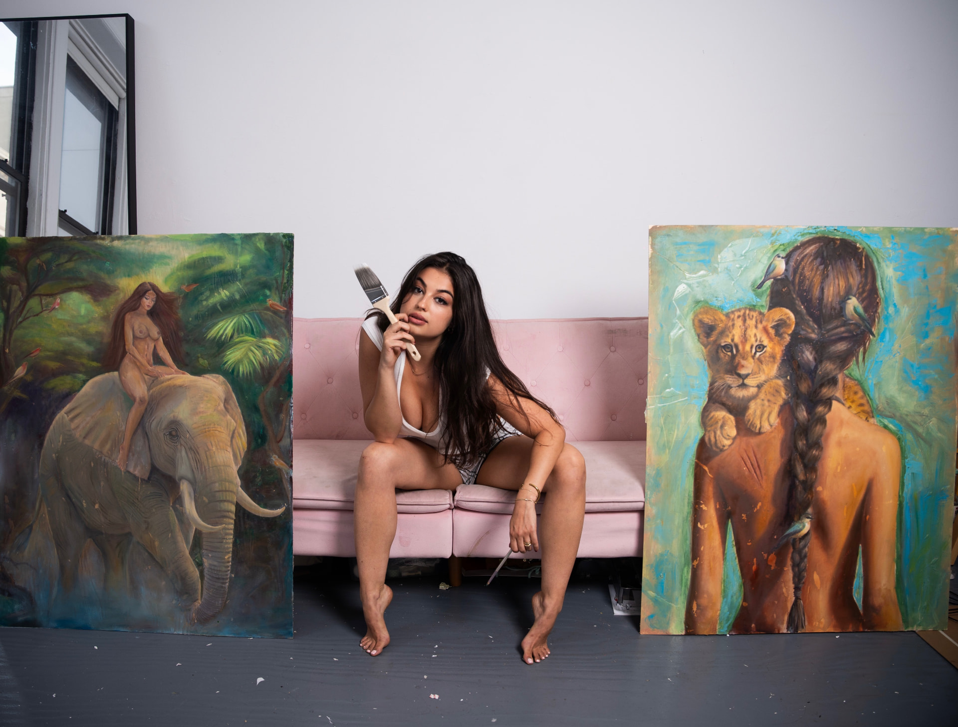 Renée Monaco in her Tribeca studio, seated between two paintings